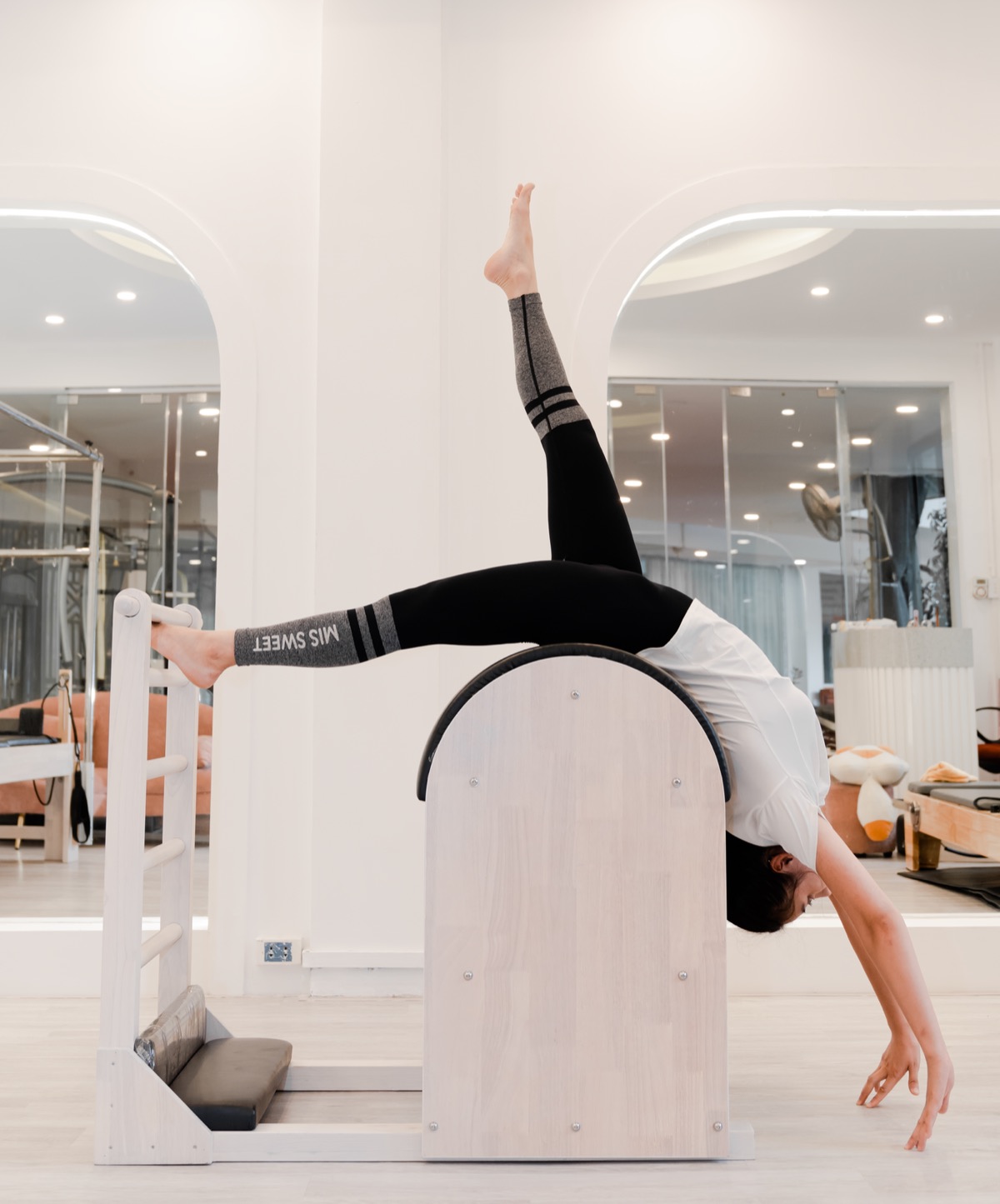 Aydınlık kemerli stüdyoda pilates barrel üzerinde esneme hareketi